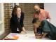 Autumn Fabricant, left, site coordinator for the Bright Futures program at Willow Run, helps eighth grade student, Ayleo Bowles, and his father, Jumaane Bowles, sign up for summer programming at the Freshman Flyer Academy informational dinner Thursday.