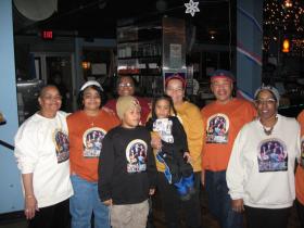 Donning shirts crated by Ypsilanti resident Norma Starks, left, Sally Johnson, Sennie Harris, Javette Starks, Tonia Del-Radio, Reginald Adielph,Thomas Del-Radio and Vickie Clay, pose for a photo at the inauguration party in Club Divine last night.